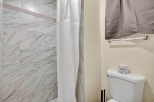 a bathroom with a white shower curtain and a toilet at Eagle Motel Suite 108 in Manitou Springs