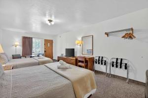 a hotel room with two beds and a mirror at Eagle Motel Suite 108 in Manitou Springs