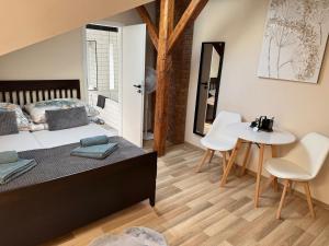 a bedroom with a bed and a table and chairs at Apartmány Kukučín in Košice