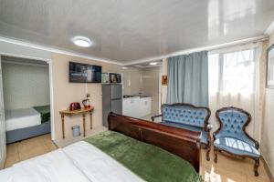 a bedroom with a bed and a chair in it at Self Contained 2 bed Room Condo in Parow