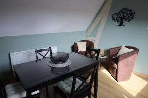 a dining room with a black table and chairs at S'Kamèrlè in Hatten