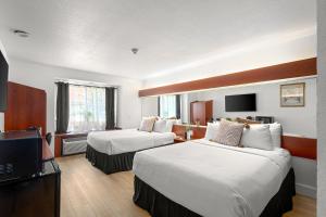 a hotel room with two beds and a flat screen tv at The Block Hotel Bentonville in Bentonville +92 photos