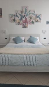 a bed in a room with two pictures on the wall at Il Viandante in Catanzaro