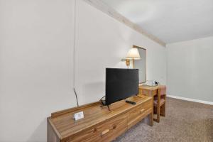 a flat screen tv sitting on top of a wooden dresser at Eagle Motel Suite 112 in Manitou Springs