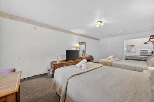 a hotel room with two beds and a television at Eagle Motel Suite 112 in Manitou Springs