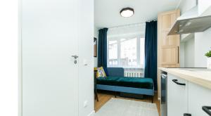 a kitchen with a blue bench in front of a window at Sõle Studios by RevalHome in Tallinn