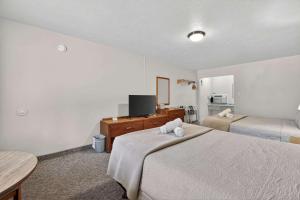 a hotel room with two beds and a television at Eagle Motel Suite 114 in Manitou Springs