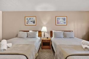 a hotel room with two beds and a lamp at Eagle Motel Suite 114 in Manitou Springs