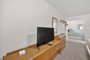 a flat screen tv sitting on top of a wooden dresser at Eagle Motel Suite 114 in Manitou Springs