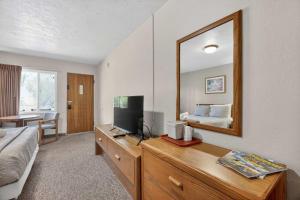 a bedroom with a bed and a television on a dresser at Eagle Motel Suite 114 in Manitou Springs +9 photos