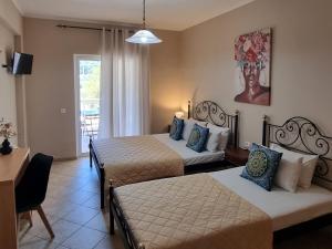 a hotel room with two beds and a television at Marathon Studios & Apartments in Keri