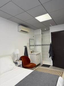 a bedroom with a bed and a chair and a sink at Casa Théodore in San-Nicolao +17 photos