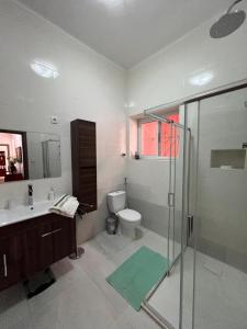 a bathroom with a toilet and a sink and a shower at Casa Tolentino in Bissau +12 photos