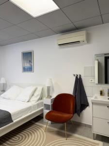 a bedroom with a bed and a chair at Casa Théodore in San-Nicolao