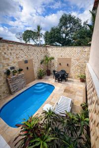 a swimming pool in a patio with a table and chairs at Pousada São José in Barreirinhas