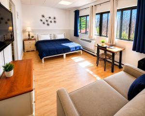 a living room with a bed and a couch at Auberge du Mont Rigaud in Rigaud