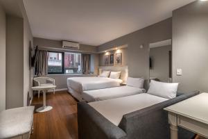 a hotel room with two beds and a couch at Up América Plaza in Buenos Aires +58 photos