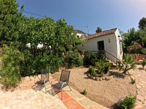 two chairs sitting on a patio in front of a house at Molino del Caracol in Benaoján