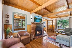a living room with a fireplace and a tv at Harmony Hideaway Hammocks Creek Sounds in Shaver Lake