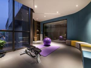 a room with a gym with a purple exercise ball and a bench at Mercure Suzhou Downtown in Suzhou