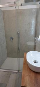 a shower with a glass door next to a sink at Q Home San Teodoro Centro in San Teodoro