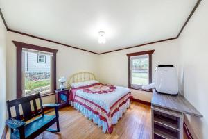 a bedroom with a bed and a chair and windows at Enchanting Adobe in Lead
