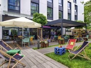 a patio with chairs and tables and umbrellas at ibis Styles Warszawa Centrum in Warsaw