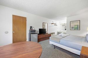 a bedroom with a bed and a table and a tv at Eagle Motel Suite 226 in Manitou Springs