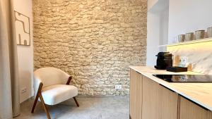 a kitchen with a chair and a stone wall at BOGORIA Apartments in Uniejow +42 photos