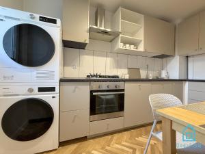a kitchen with white appliances and a table at Harbor Room at City Center Gdynia & Seaside in Gdynia
