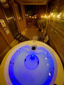 a bath tub with a blue light in a room at Romantic Tiny House with Private Jacuzzi and Garden between Amsterdam Haarlem and Schiphol Airport in Vijfhuizen