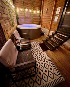 a bathroom with a tub and a chair and a table at Romantic Tiny House with Private Jacuzzi and Garden between Amsterdam Haarlem and Schiphol Airport in Vijfhuizen