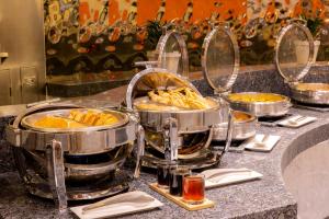 a buffet with three pots of food on a counter at Barceló México Santa Fe in Mexico City