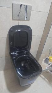 a black toilet with a black seat in a bathroom at Dar D'Asilah in Asilah