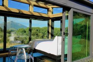 a bedroom with a view of a mountain through windows at Kahutara PurePod in Kaikoura
