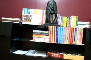 a book shelf filled with books and a statue at FX Pena in Funchal