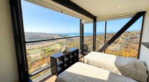 a bedroom with two beds and a view of the ocean at Olas de Pichicuy in Guaquen