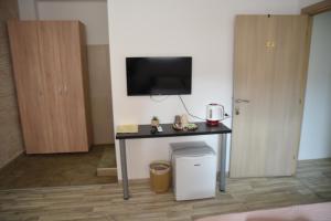 a room with a table with a tv on a wall at Apartment Friends in Veles