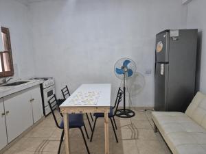 a kitchen with a table and chairs and a refrigerator at Parque de la Juventud in La Rioja +2 photos