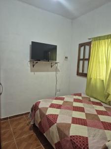 a bedroom with a bed with a tv on the wall at Parque de la Juventud in La Rioja