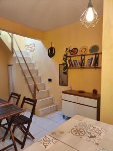 a living room with a staircase and a table and chairs at Hostel Leda Beach in Canoa Quebrada