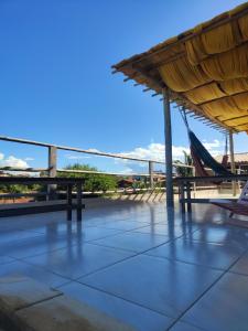 a building with a roof with a view of a boat at Hostel Leda Beach in Canoa Quebrada