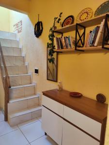 a kitchen with a staircase and a counter with books at Hostel Leda Beach in Canoa Quebrada