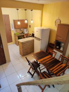a kitchen with a table and chairs and a refrigerator at Hostel Leda Beach in Canoa Quebrada