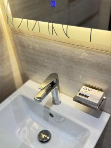 a bathroom sink with a faucet and a book on it at شقة أنيقة جديده في قلب أبها in Abha +13 photos