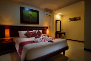 Postel nebo postele na pokoji v ubytování Adi Dharma Hotel Legian