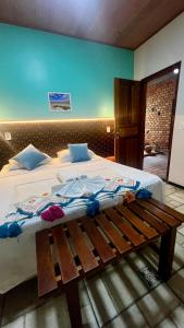 a bedroom with a large bed with a wooden bench at Pousada São José in Barreirinhas