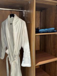 a white robe is hanging in a closet at شقة أنيقة جديده في قلب أبها in Abha