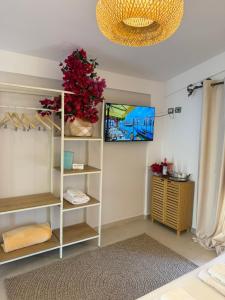 a room with a white shelf with red flowers on it at Hotel Imperial in Dhërmi