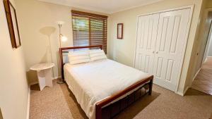 a bedroom with a bed and a window and a door at Coastal Haven on Sandpiper in Broadwater